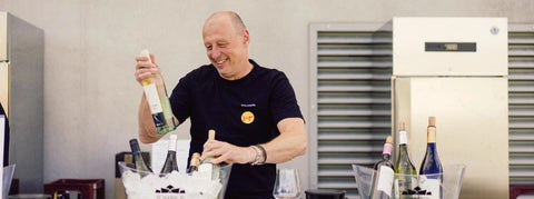 Mann hält Weinflasche in der Hand