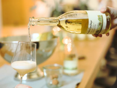 Es wird Saftschorle in ein Weinglas eingeschenkt. Es schäumt im Glas.